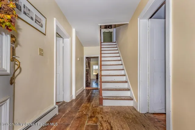 a view of a hallway with wooden floor and entryway