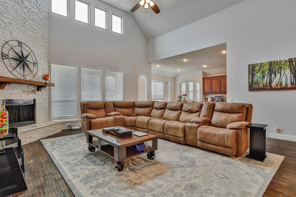 2425 Turning Leaf Lane Midlothian, TX 76065 - Photo 15 of 29 Living room with a ceiling fan, dark wood-style flooring, a stone fireplace, high vaulted ceiling, and recessed lighting