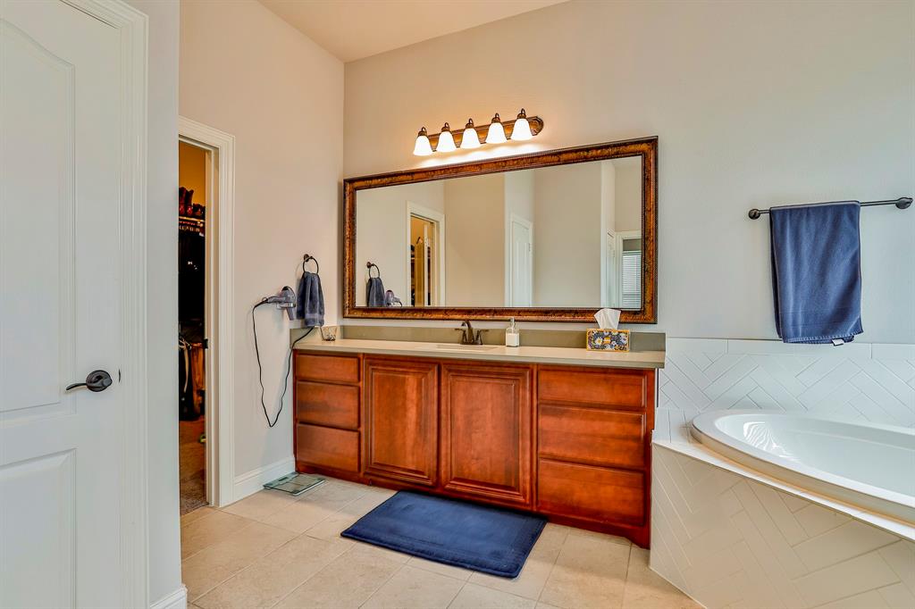 2425 Turning Leaf Lane Midlothian, TX 76065 - Photo 19 of 29 Full bathroom featuring vanity, light tile patterned floors, a garden tub, and a walk in closet