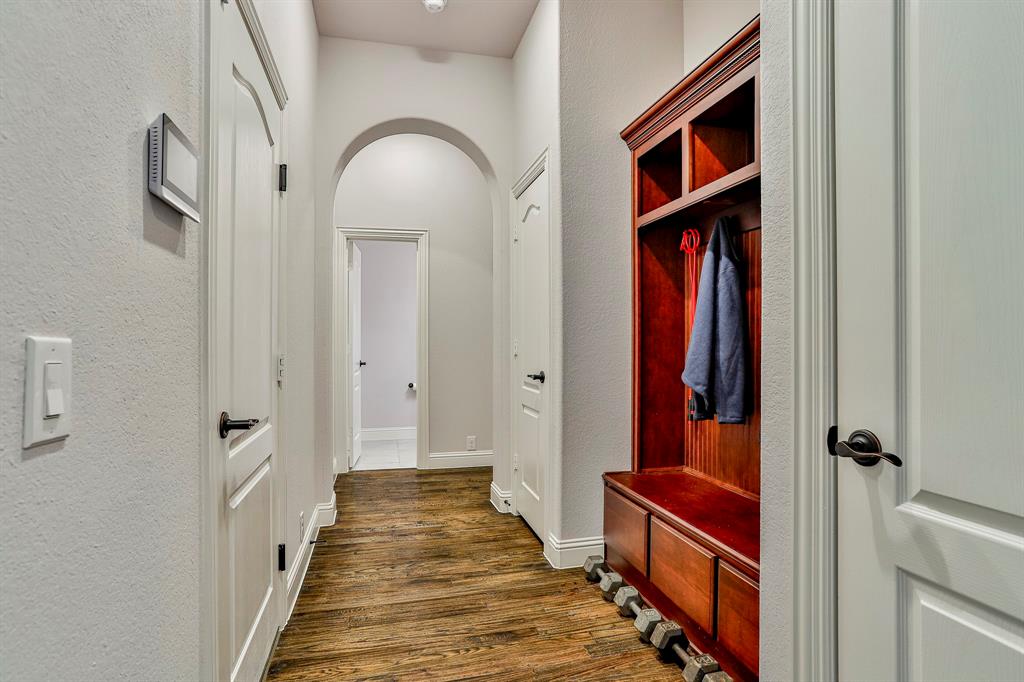 2425 Turning Leaf Lane Midlothian, TX 76065 - Photo 9 of 29 Mudroom featuring dark wood-type flooring, a textured wall, and arched walkways
