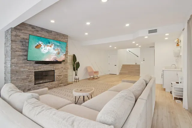 a living room with furniture a fireplace and a flat screen tv