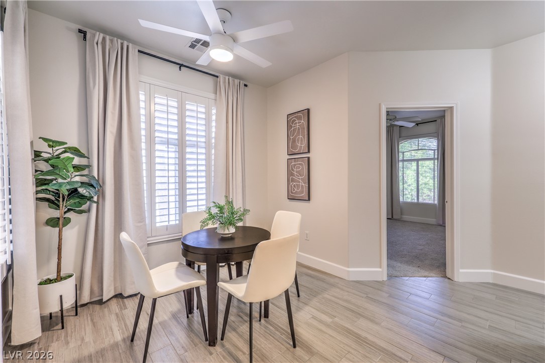 2050 West Warm Springs Road, Unit 1421 Henderson, NV 89014 - Photo 13 of 45 Natural light streams into this intimate dining area, complementing the plank flooring and crisp white palette.