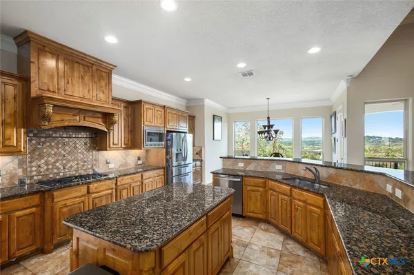 a kitchen with stainless steel appliances granite countertop sink stove and granite counter top