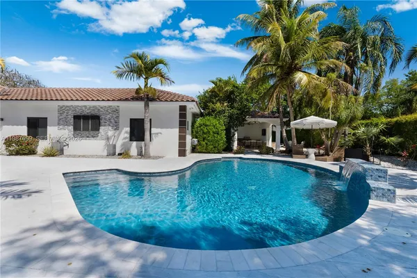a view of backyard with swimming pool and outdoor seating