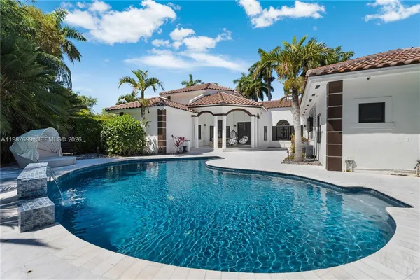 a view of a yard with plants and large trees