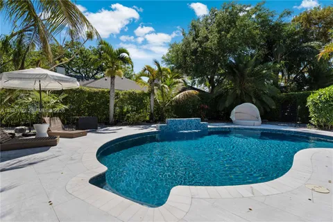 an aerial view of residential house with outdoor space and trees all around
