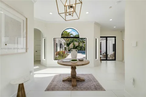 a living room with furniture a table and a large window