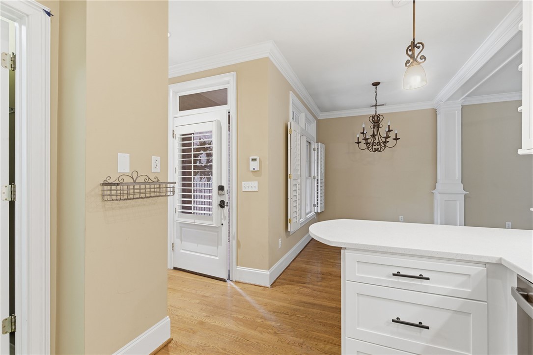 204 Butler Avenue Greenville, SC 29601 - Photo 16 of 26 Hardwood floors guide you from the entry door to the inviting dining area, illuminated by a classic chandelier.