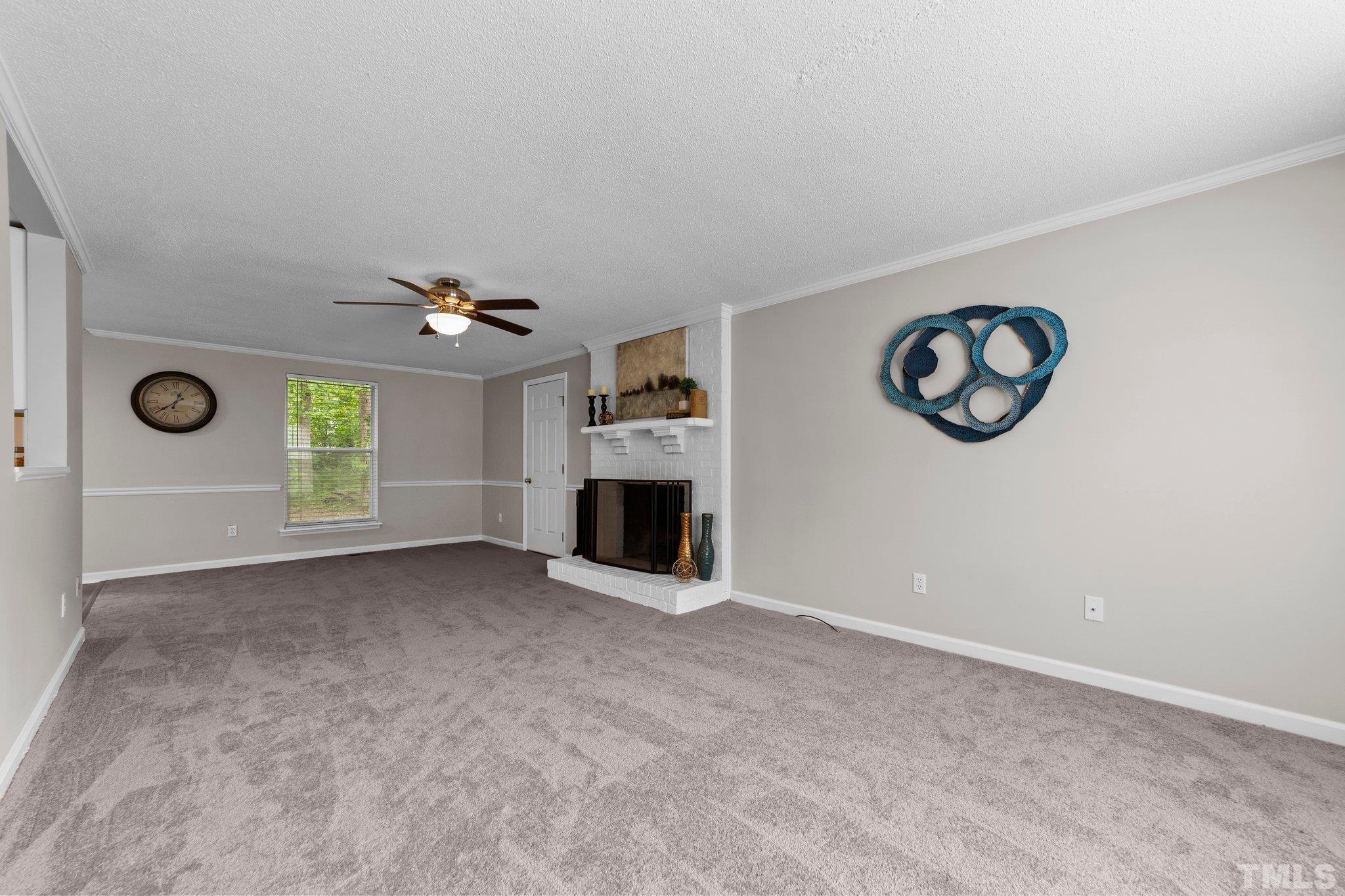 7120 Shellburne Drive Raleigh, NC 27612 - Photo 8 of 22 an empty room with windows and fireplace