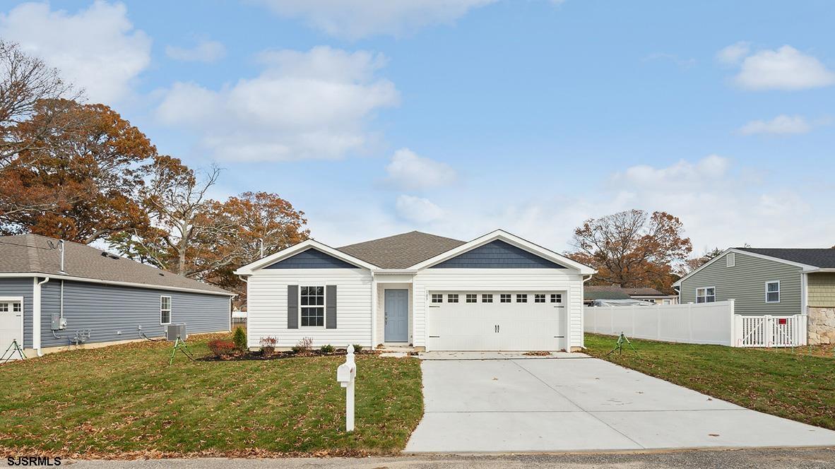 a view of a house with a yard and fence