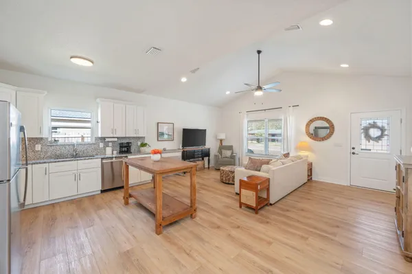 a living room with furniture appliances and wooden floor