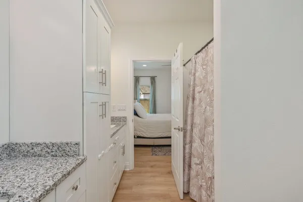 a en suite bathroom with a granite countertop sink and a mirror