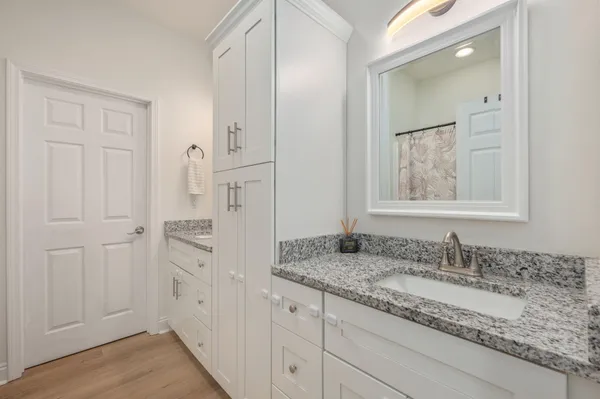 a bathroom with granite countertop a sink and a mirror