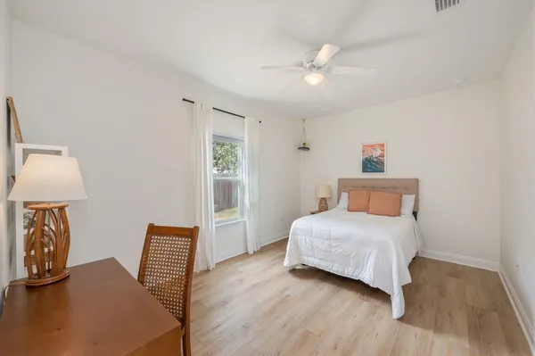 a bedroom with a bed and wooden floor