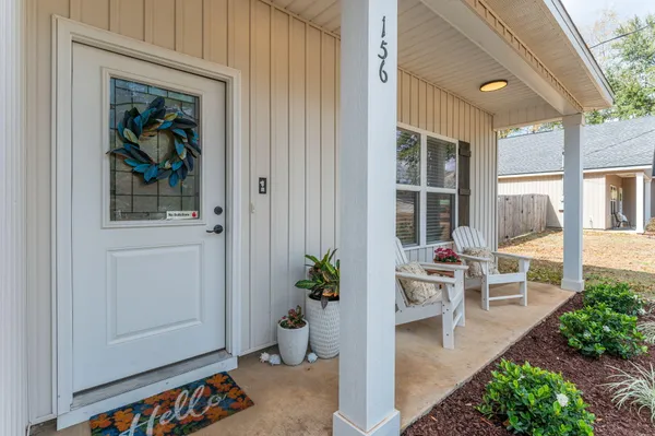 a view of a porch with chairs and potted plants