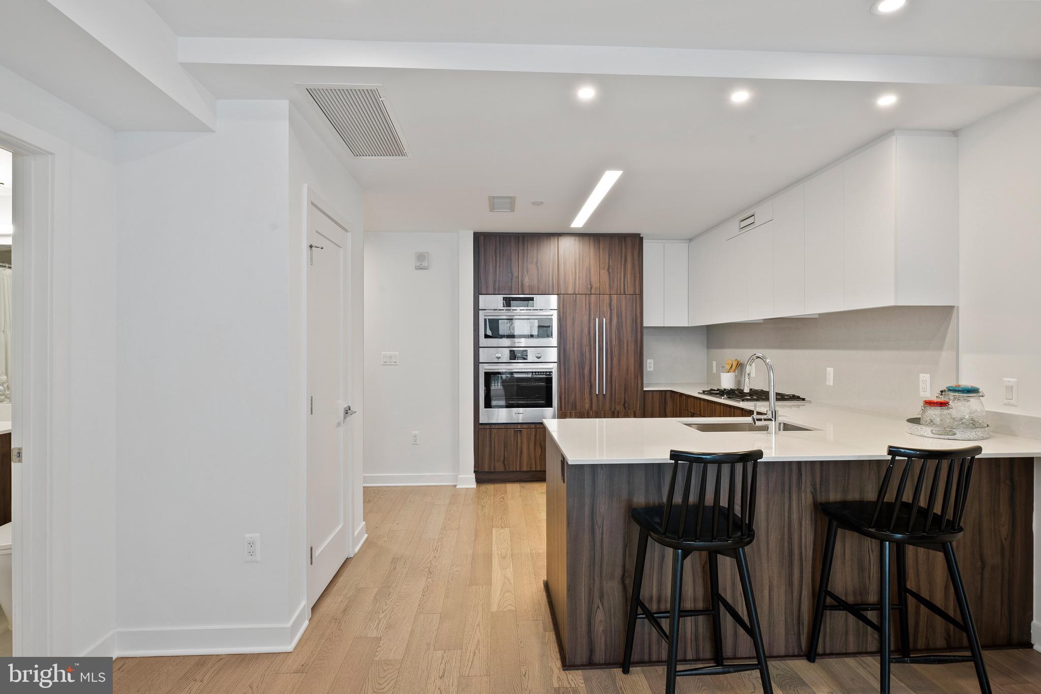 37 L Street Southeast, Unit 908 Washington, DC 20003 - Photo 2 of 20 a kitchen with kitchen island a dining table chairs stainless steel appliances and cabinets