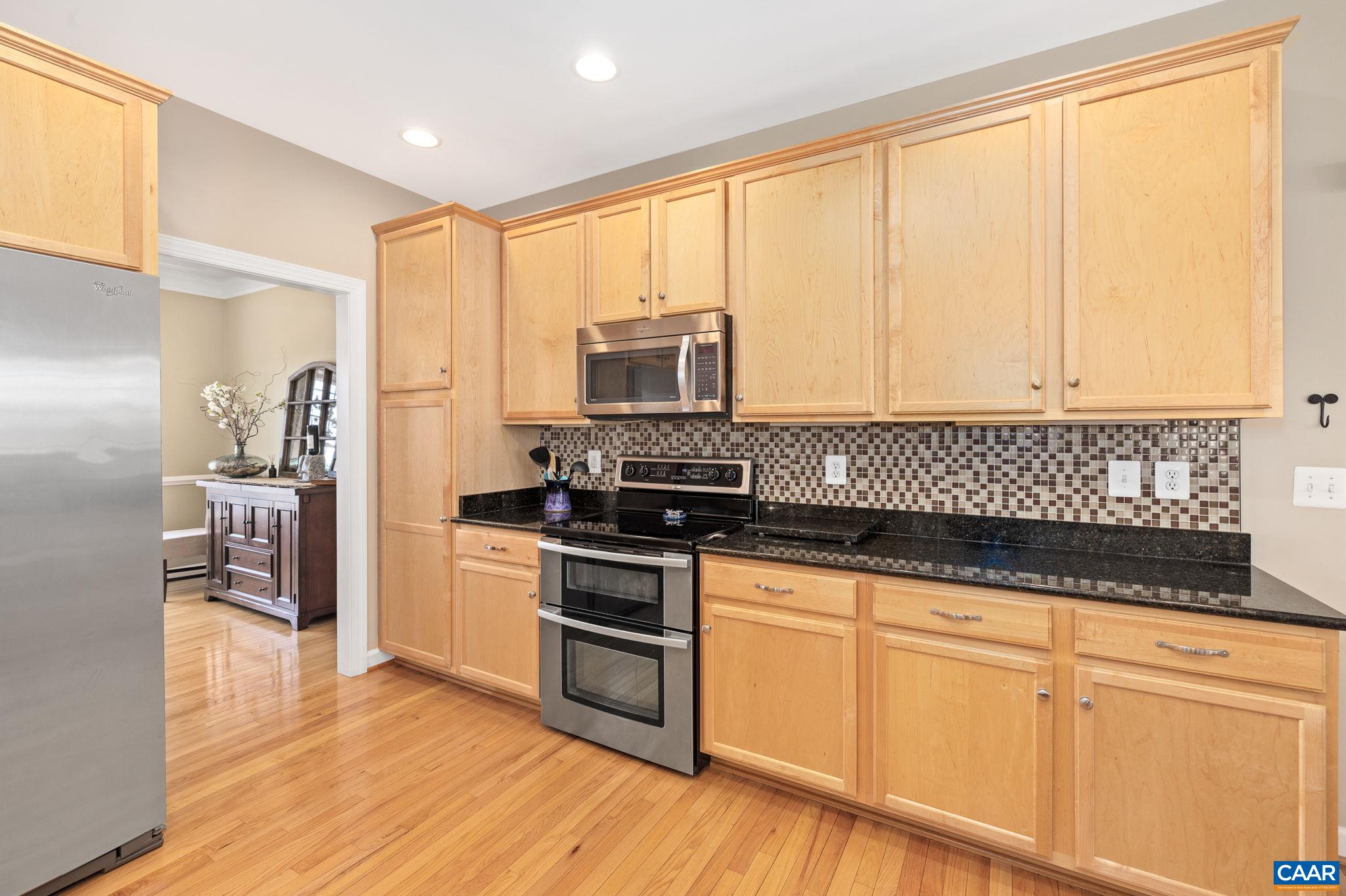 212 Wexford Ridge Road Ruckersville, VA 22968 - Photo 28 of 73 a kitchen with granite countertop white cabinets and stainless steel appliances