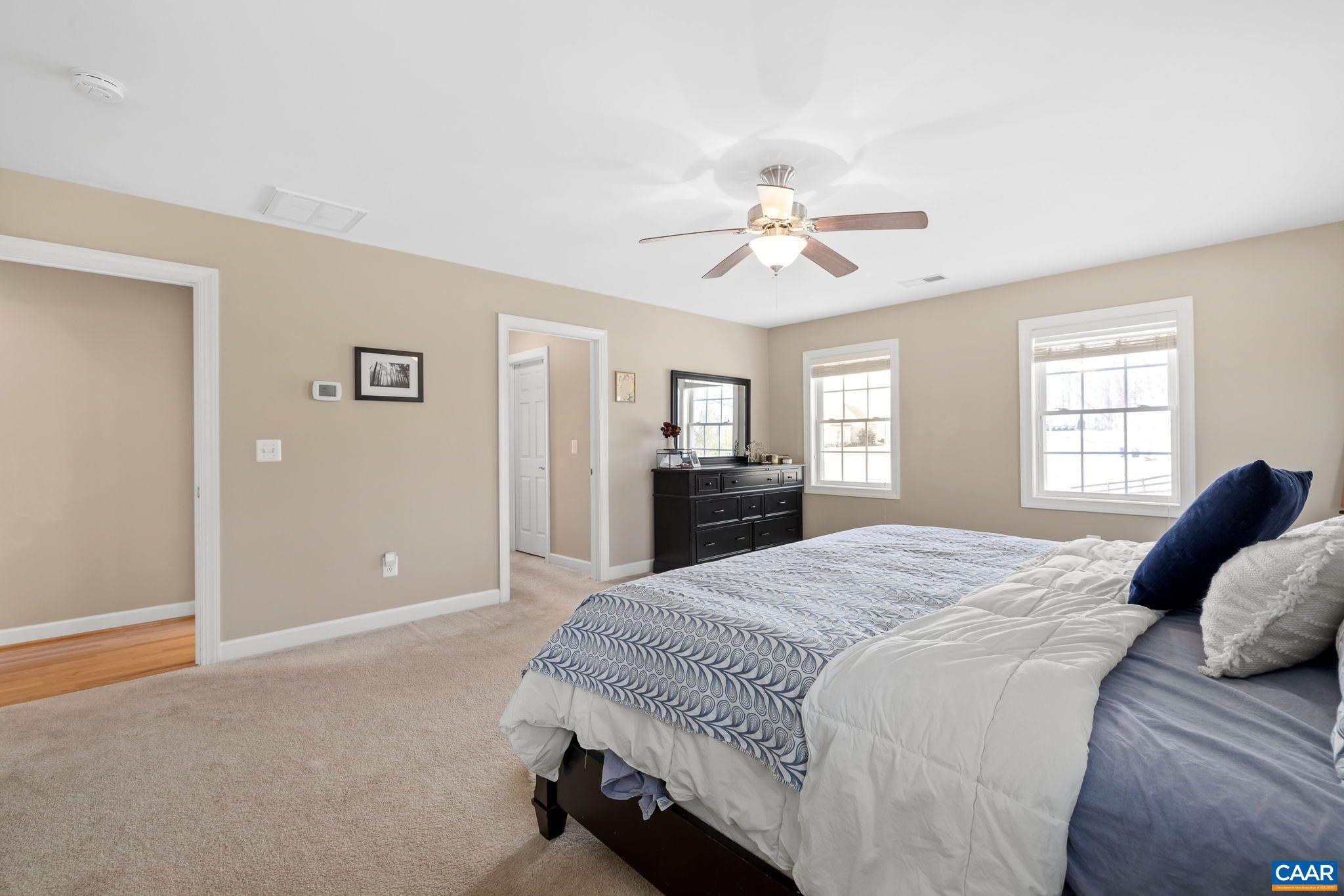 212 Wexford Ridge Road Ruckersville, VA 22968 - Photo 54 of 73 a spacious bedroom with a large bed a chandelier and window