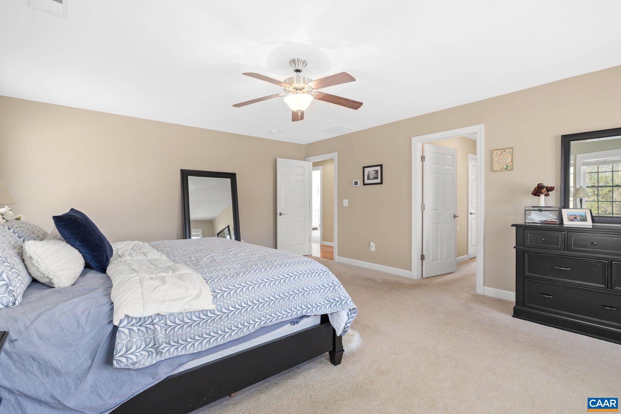 212 Wexford Ridge Road Ruckersville, VA 22968 - Photo 55 of 73 a bedroom with a bed and a chandelier