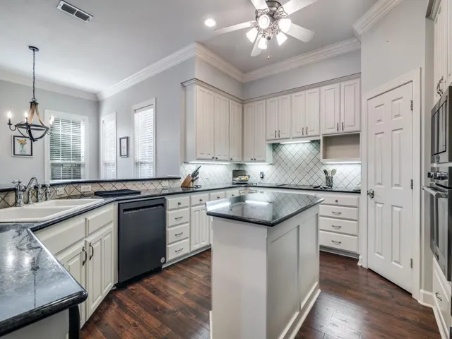 a kitchen with granite countertop cabinets stainless steel appliances a sink and a island