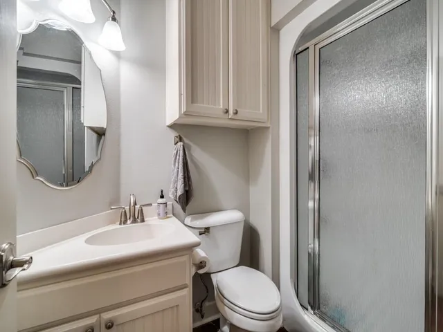 a bathroom with a toilet a sink and mirror