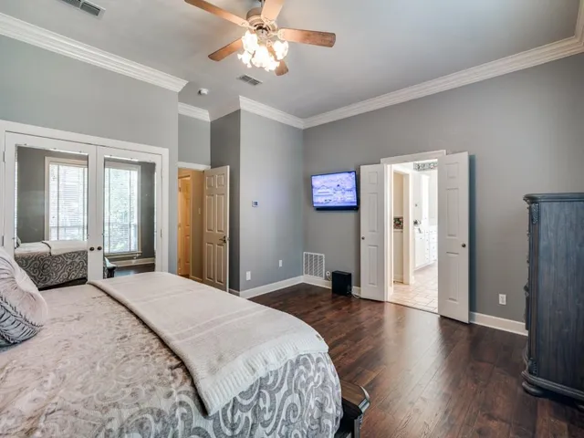 a spacious bedroom with a large bed and wooden floor