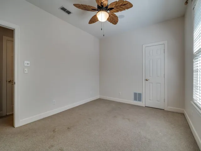 an empty room with closet and a chandelier fan