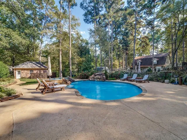 a view of a swimming pool with lawn chairs and a fire pit