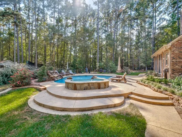 a view of a fountain in the yard with large trees