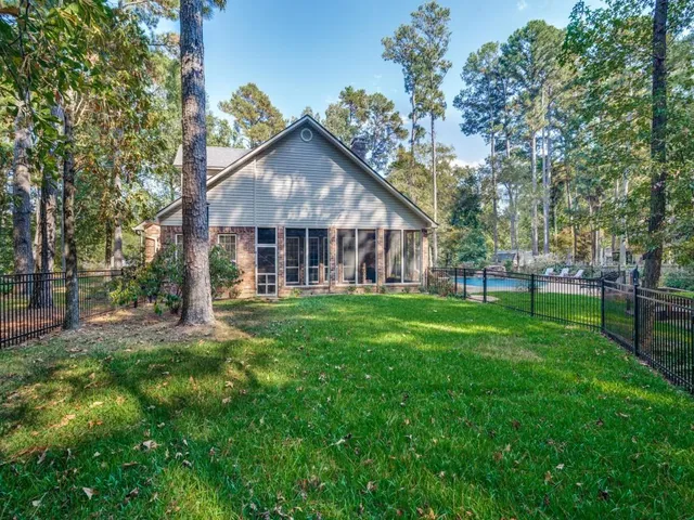 a view of a yard with table and chairs and large trees