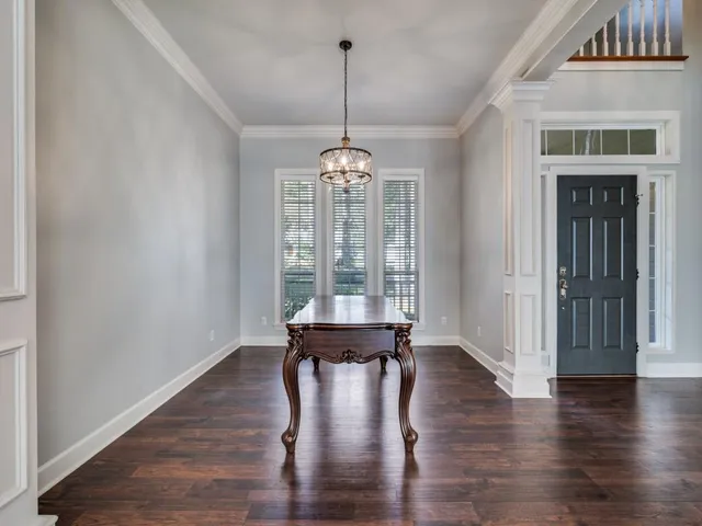 a view of a room with wooden floor water view and windows