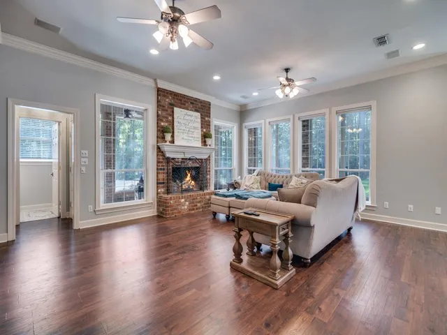 a living room with furniture fireplace and large windows