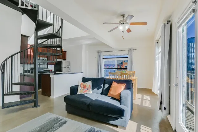 a living room with furniture and a ceiling fan