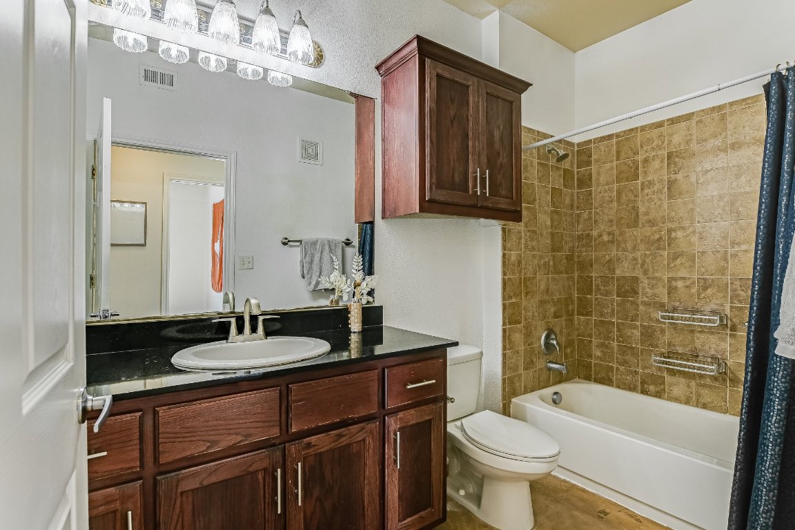 910 West 25th Street, Unit 607 Austin, TX 78705 - Photo 10 of 19 a bathroom with a sink a toilet a mirror a vanity and shower
