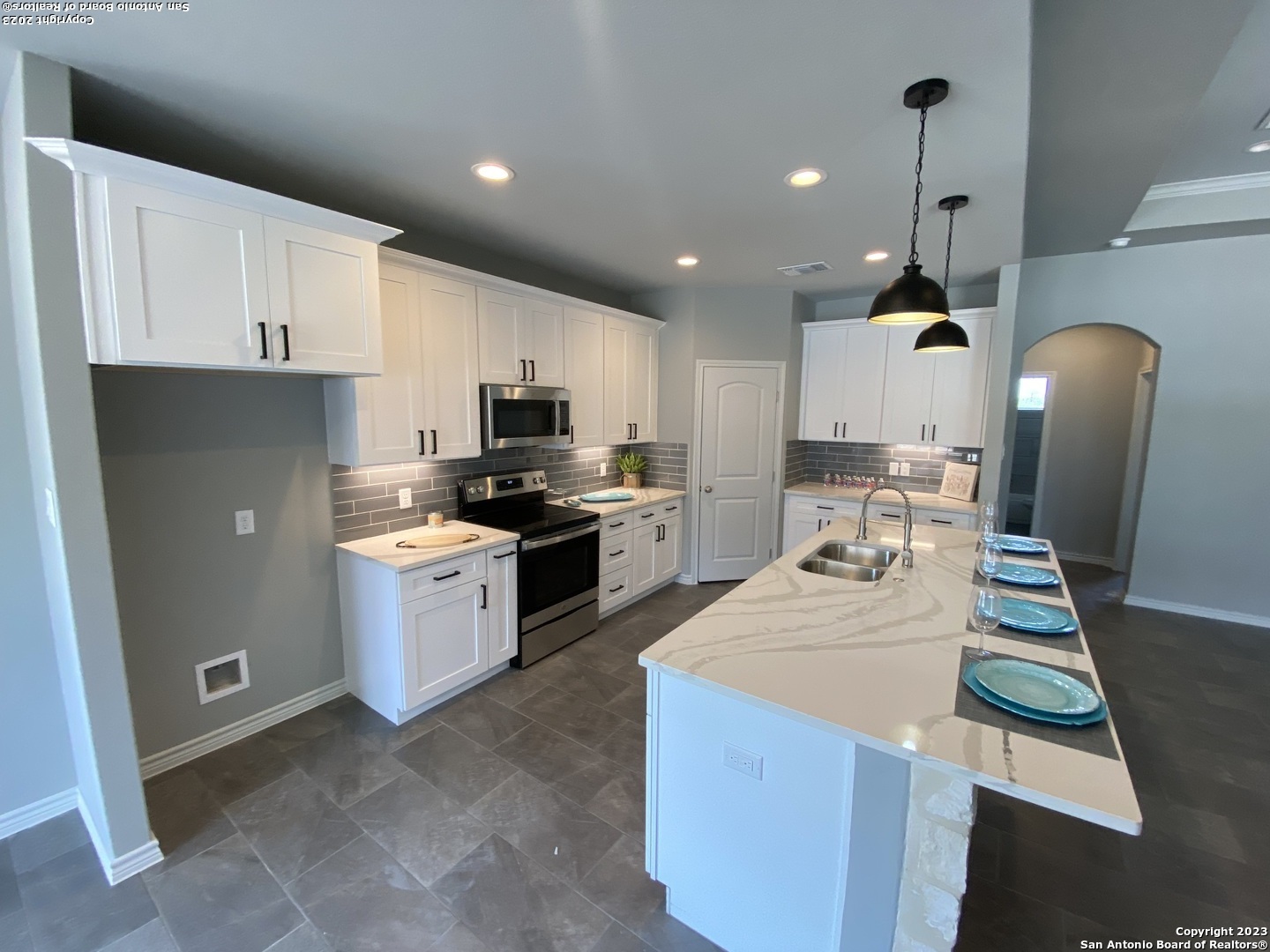 120 South Calvin Barrett Blanco, TX 78606 - Photo 4 of 18 a kitchen with granite countertop white cabinets sink and stainless steel appliances