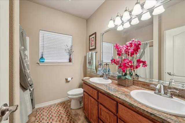 a bathroom with a sink vanity mirror and toilet