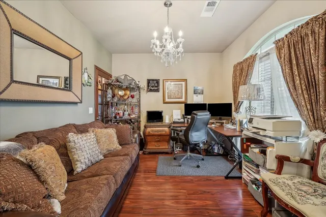 a living room with furniture a fireplace and a chandelier