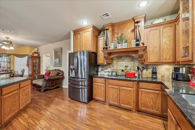 a kitchen with stainless steel appliances a stove refrigerator sink and wooden cabinets