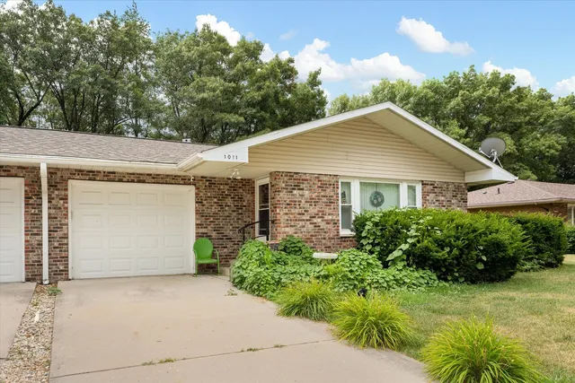 a view of a white house with a yard and garage