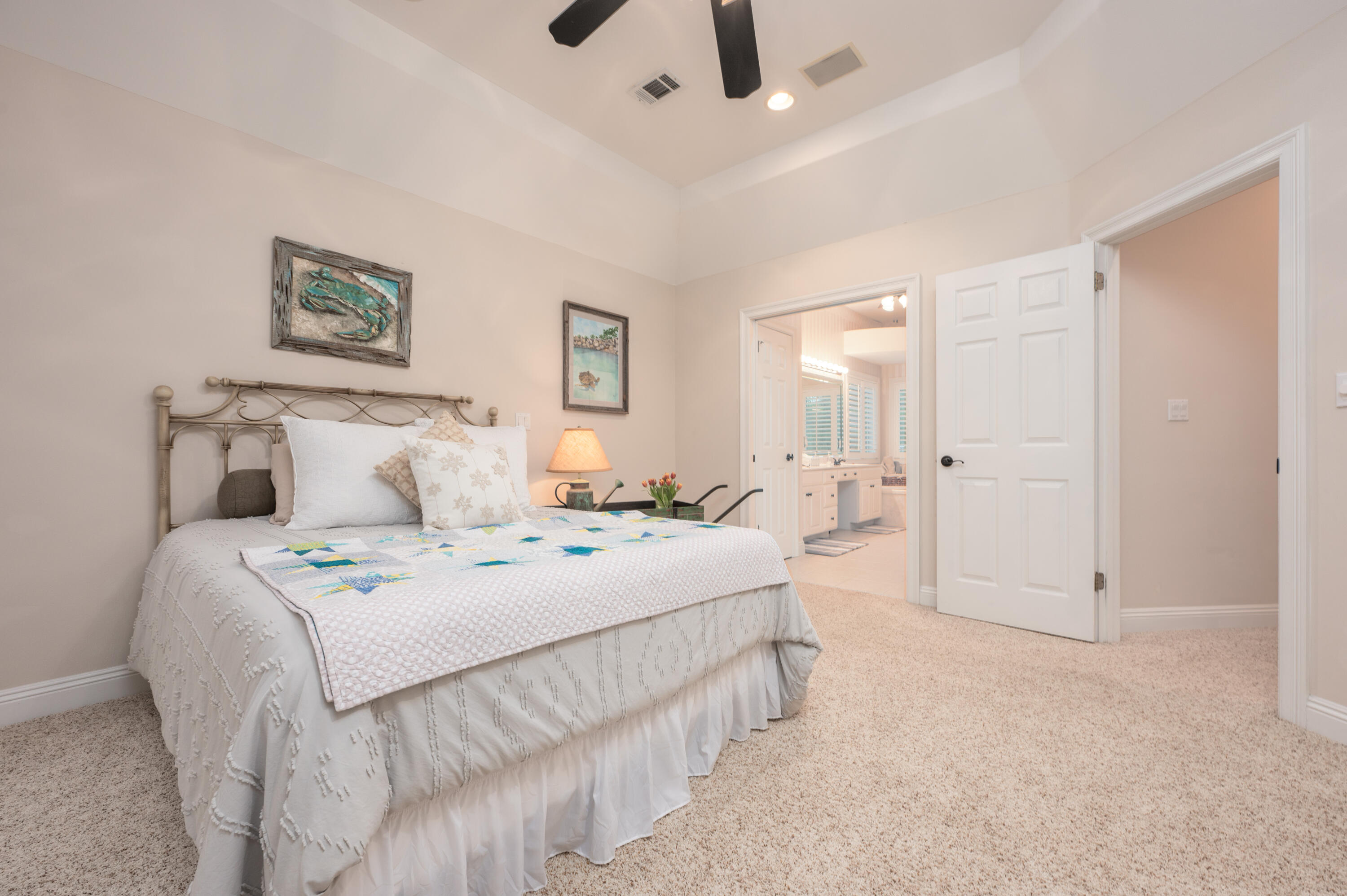 1325 Windrush Cove Niceville, FL 32578 - Photo 48 of 70 a spacious bedroom with a bed a couch and a chandelier fan