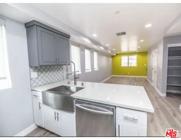 a kitchen with stainless steel appliances granite countertop a sink a stove and a refrigerator