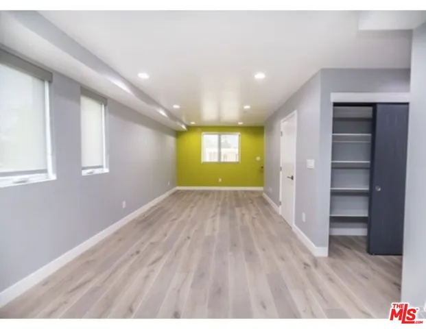 a view of empty room with wooden floor and window
