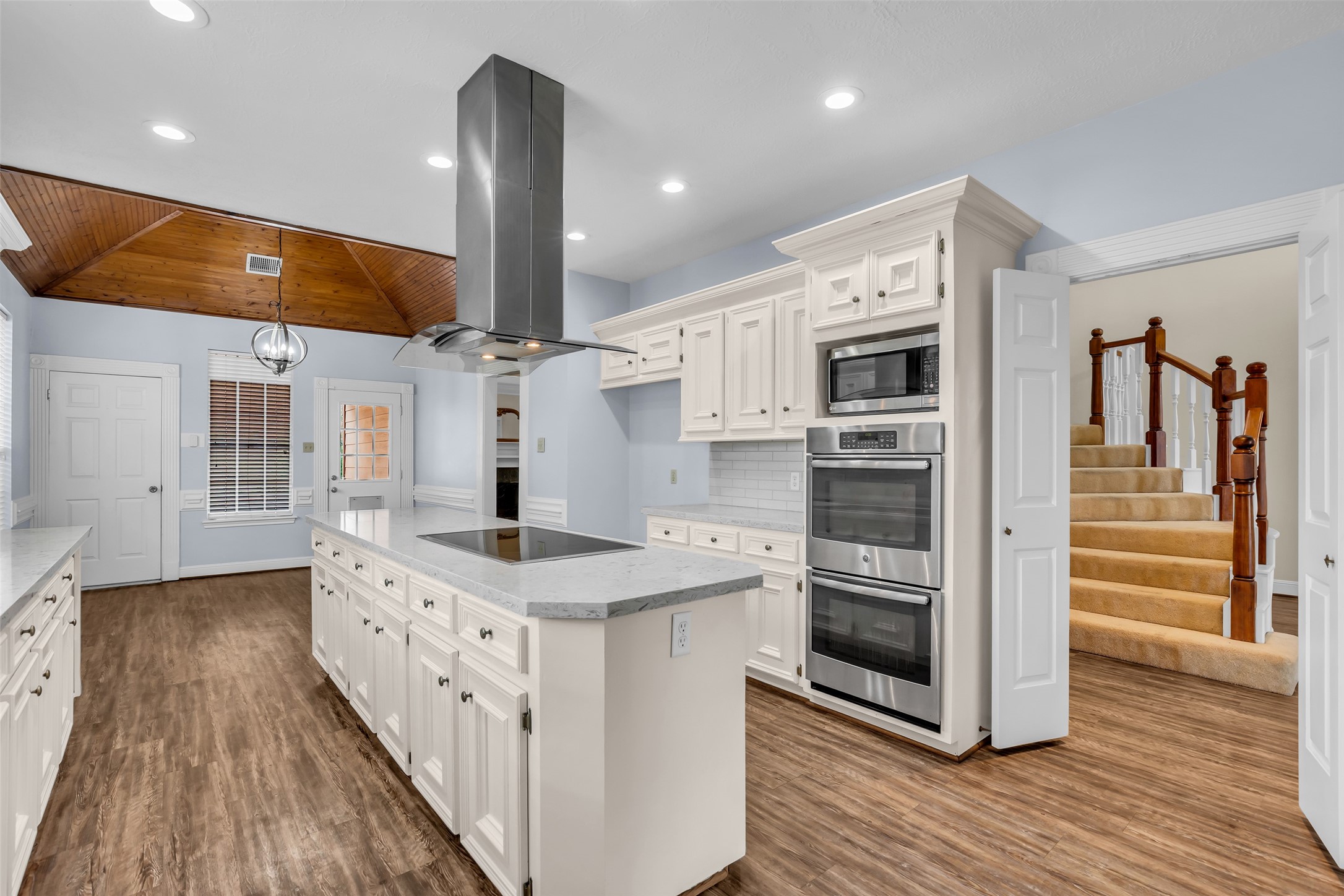 a kitchen with stainless steel appliances kitchen island granite countertop a stove and a refrigerator