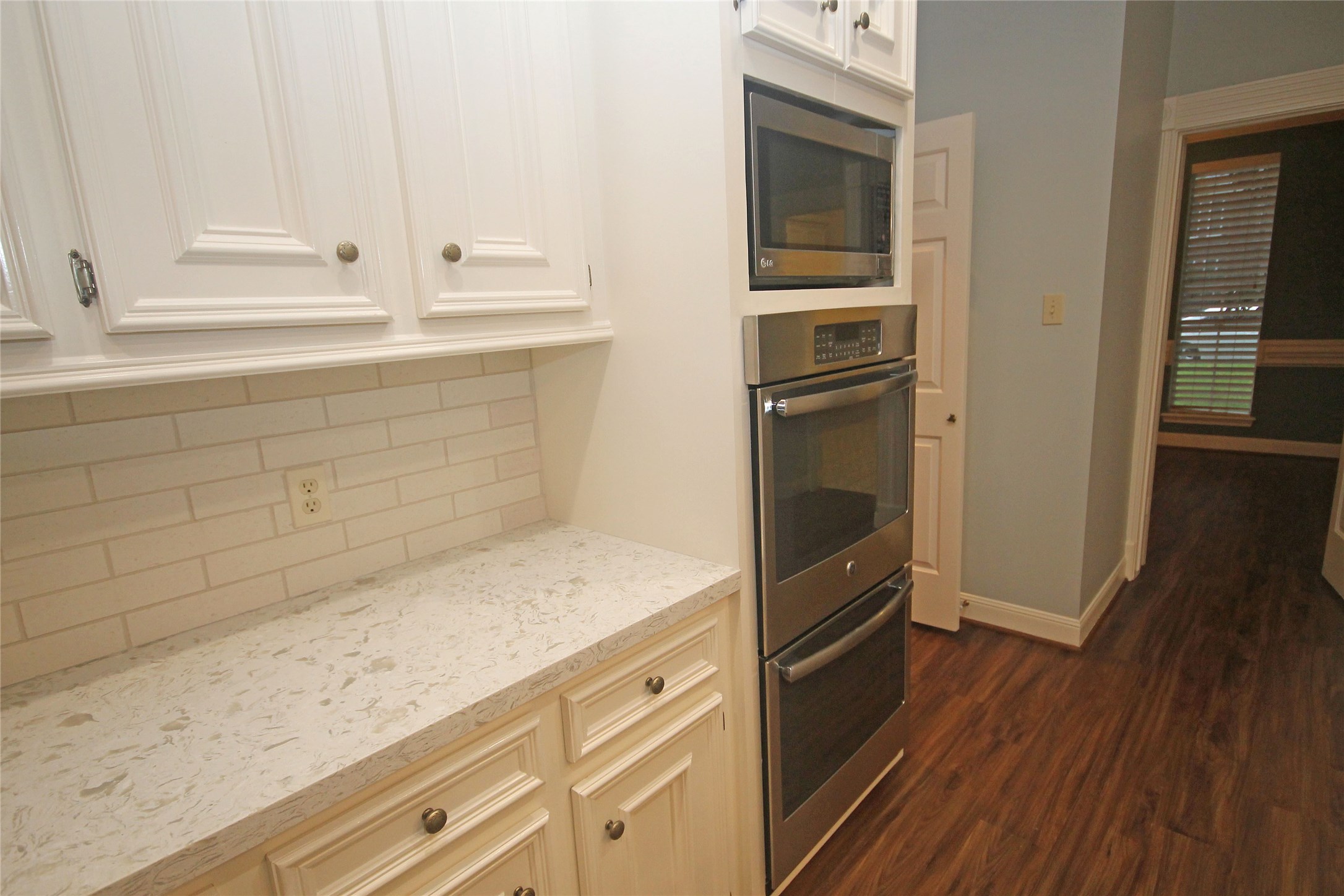 17703 Forest Park Lane Spring, TX 77379 - Photo 12 of 40 a kitchen with granite countertop white cabinets and wooden floor