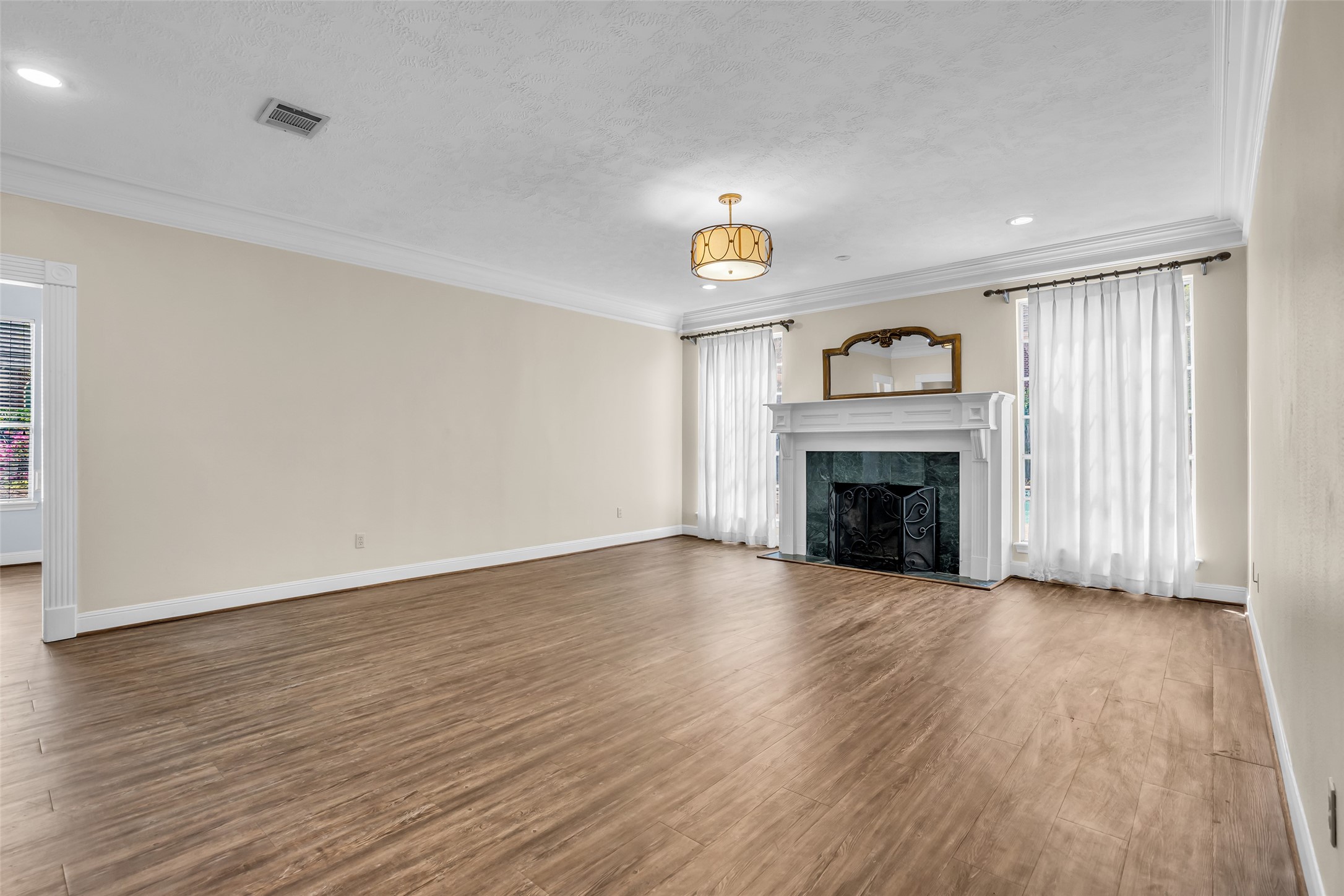 17703 Forest Park Lane Spring, TX 77379 - Photo 16 of 40 a view of an empty room with wooden floor fireplace and a window