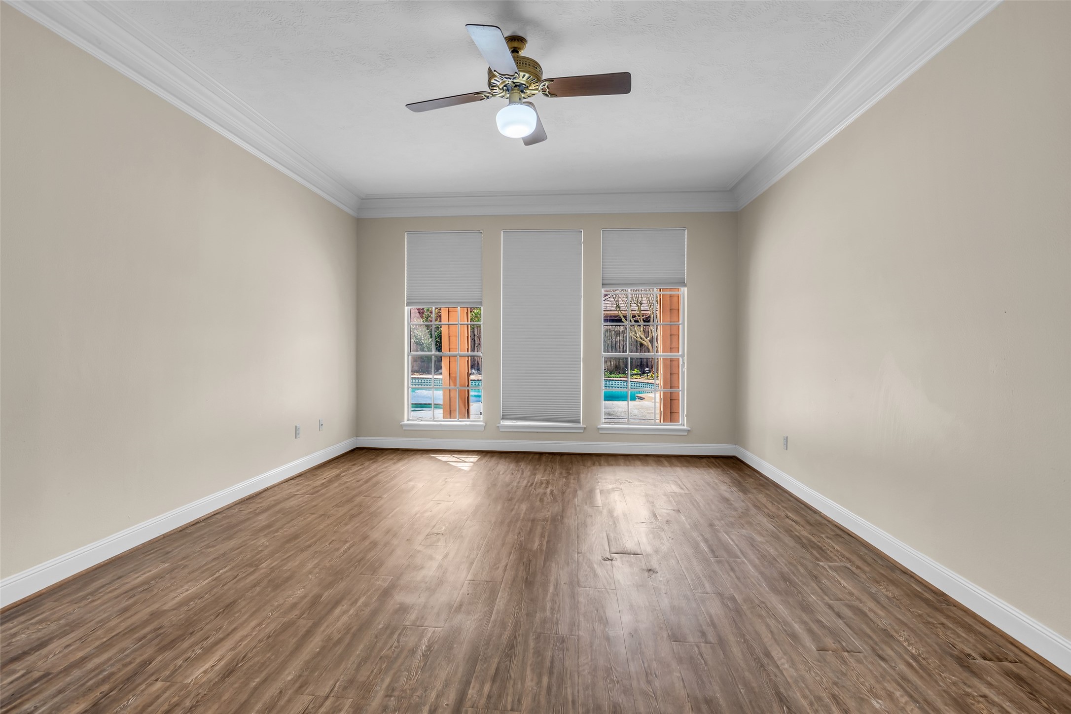 17703 Forest Park Lane Spring, TX 77379 - Photo 18 of 40 an empty room with wooden floor chandelier fan and windows