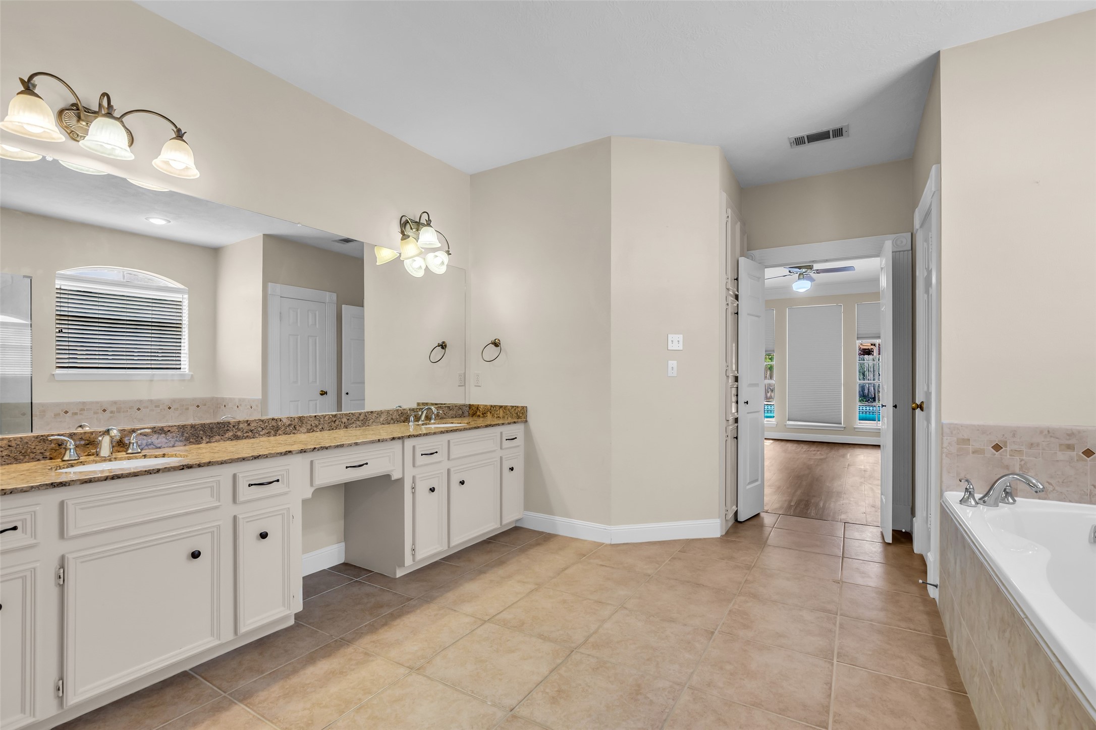 17703 Forest Park Lane Spring, TX 77379 - Photo 21 of 40 a large bathroom with a granite countertop sink large mirror a bathtub and shower