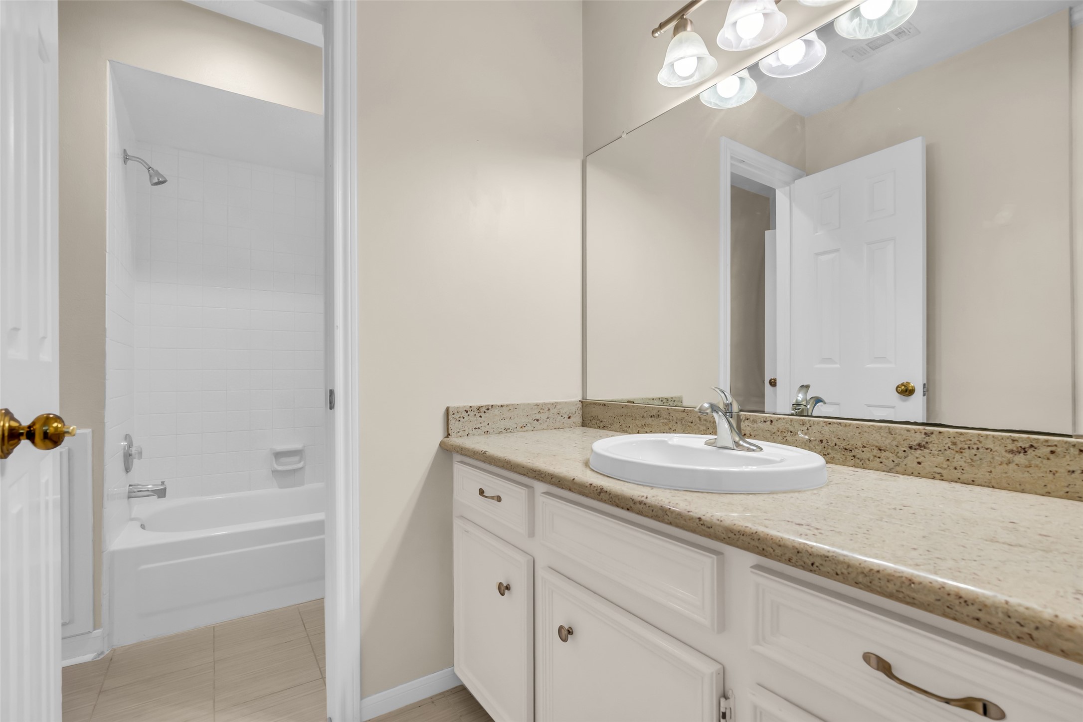 17703 Forest Park Lane Spring, TX 77379 - Photo 33 of 40 a bathroom with a granite countertop sink a mirror and a bathtub