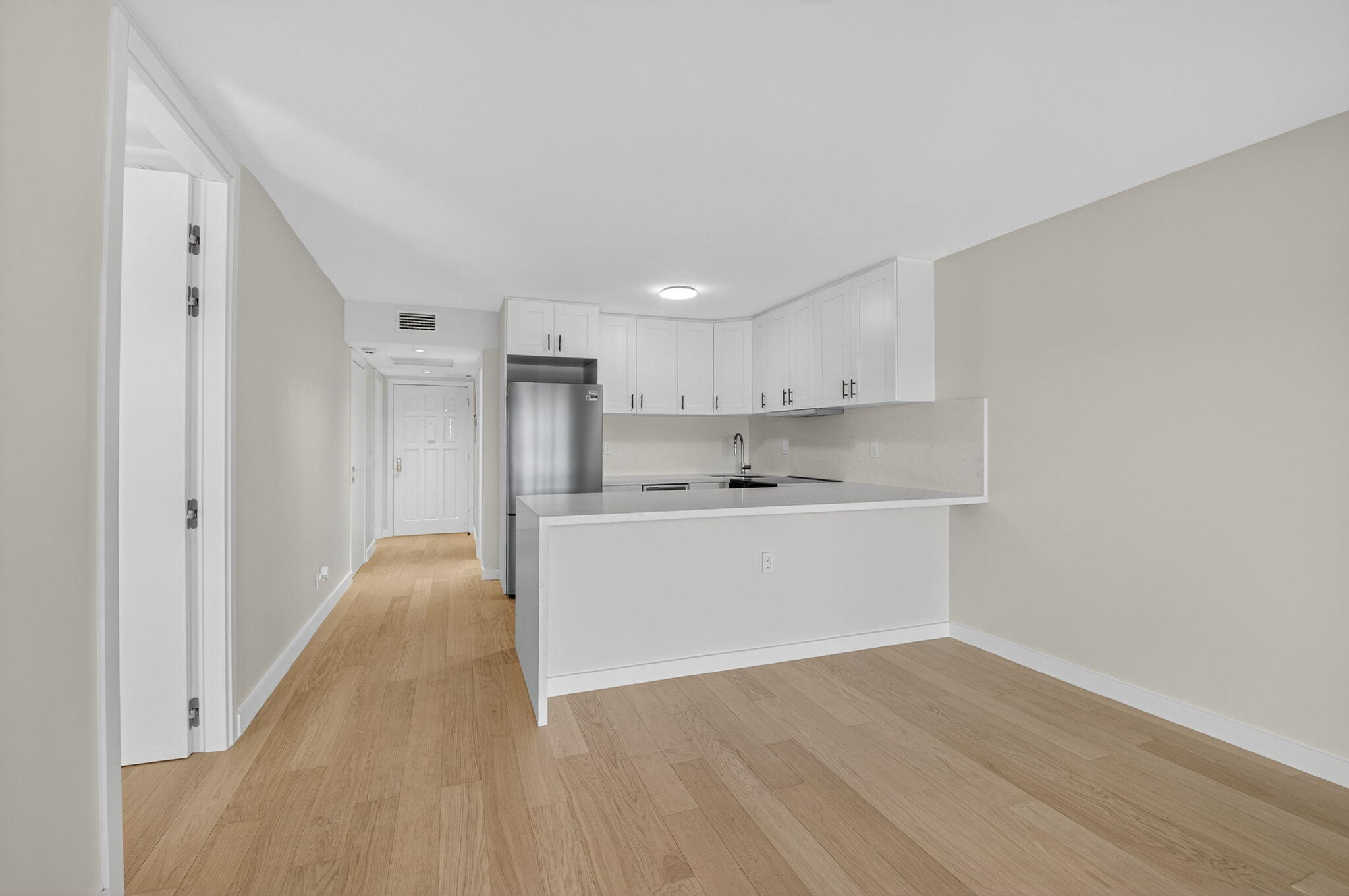 2871 North Ocean Boulevard, Unit V543 Boca Raton, FL 33431 - Photo 5 of 62 a view of a kitchen with white cabinets and wooden floor