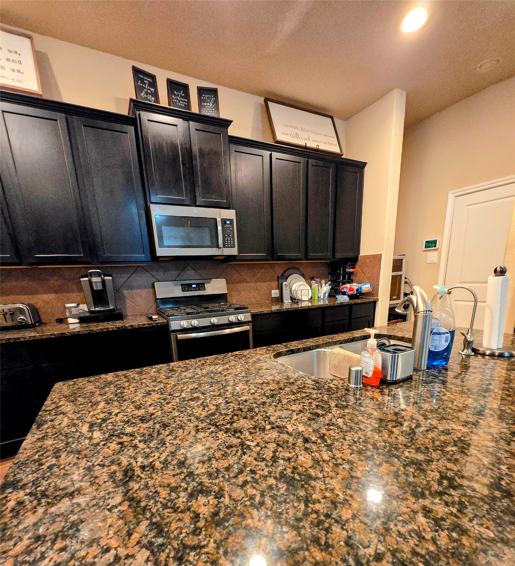 17451 Farm Pasture Trail Hockley, TX 77447 - Photo 3 of 27 a kitchen with granite countertop a stove and a microwave